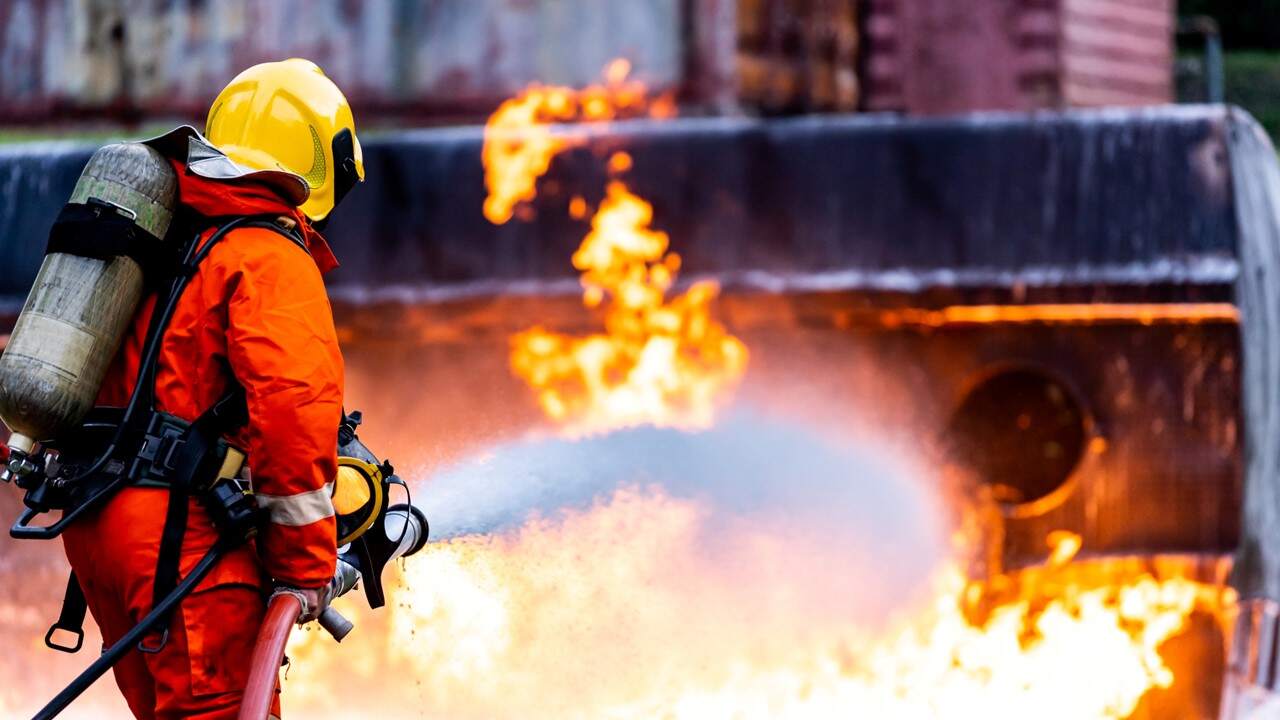 firefighter using firefighting foam to extinguish a fire